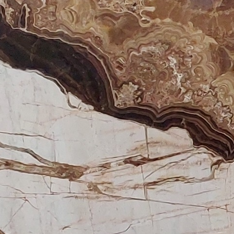 Close-up of Karyamar’s Dolonyx natural stone featuring creamy whites, soft greys, and unique patterns, ideal for luxurious architectural and interior designs